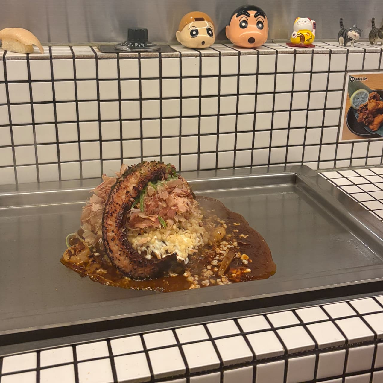 부산광역시 부산진구 야키야 본점 부산 이자카야 다찌석. 조명 아래 하얀 타일 1인석과 철판 위 가쓰오부시가 뿌려진 문어 요리로 즐기는 혼술 상황.