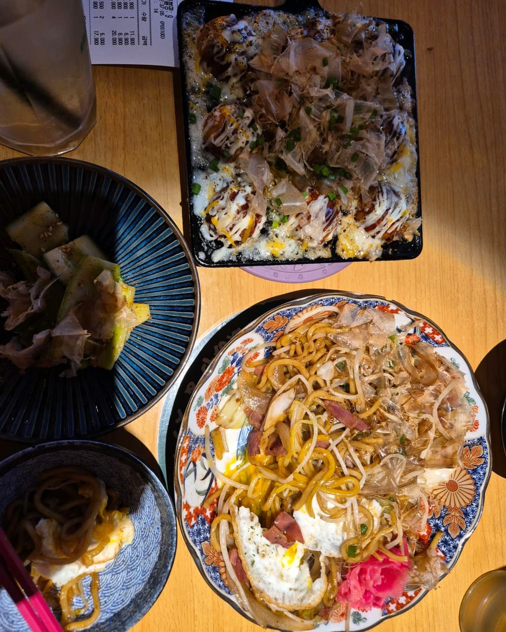 인천광역시 서해구 하타네 청라점 인천 이자카야 다찌석, 조명 아래 가쓰오부시가 뿌려진 야키소바와 타코야끼가 차려진 1인 혼술 테이블.