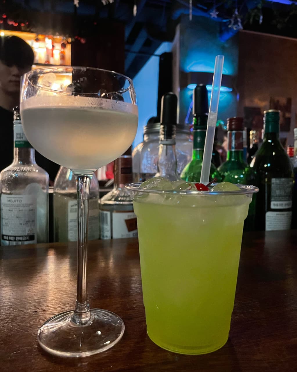 제주특별자치도 서귀포시 제주혼술바 언스테이블 서귀포점 바(Bar) 다찌석에 놓인 두 잔의 칵테일. 은은한 조명 아래 나무 테이블에서 혼술을 즐기는 모습.