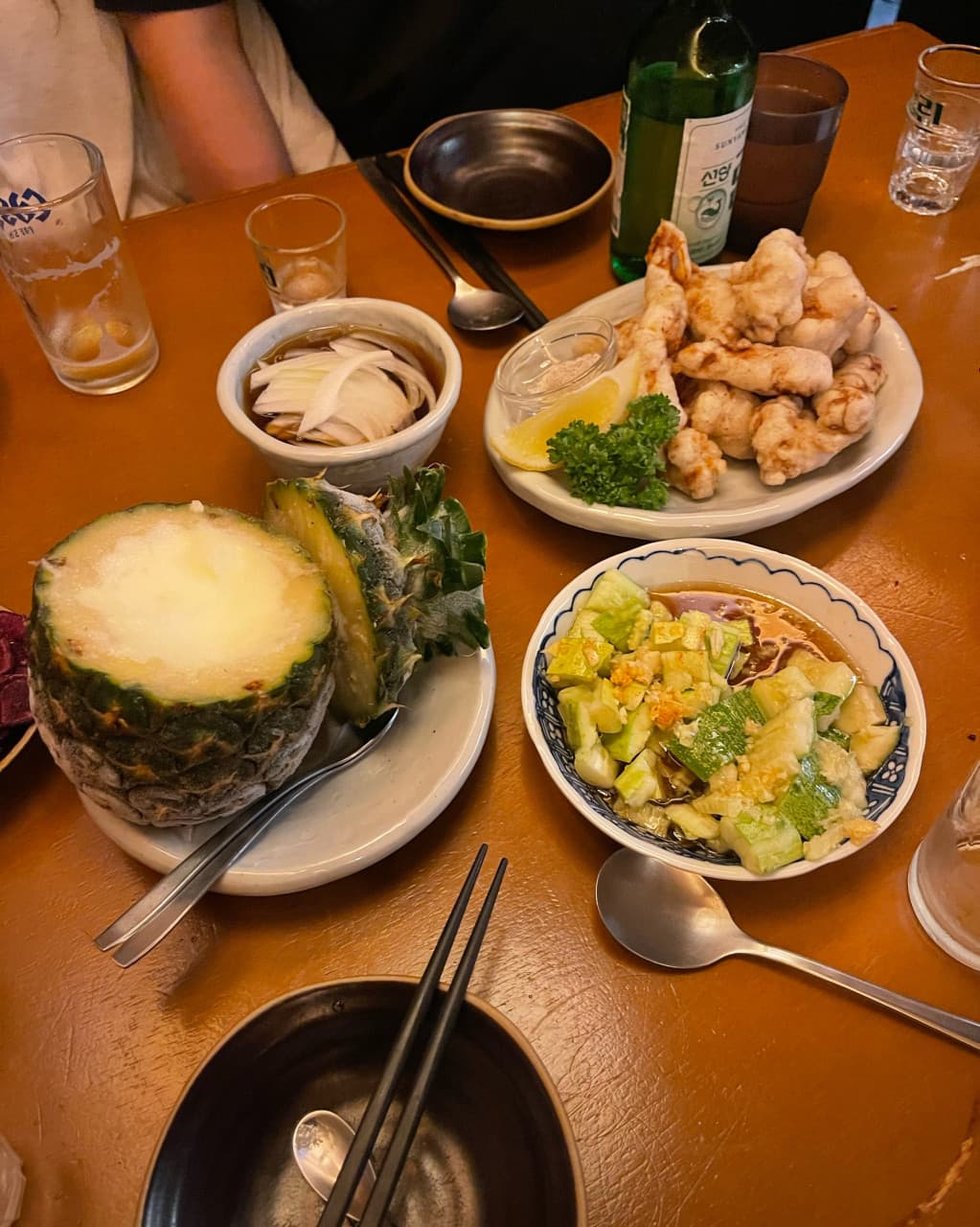 대전광역시 서구 월정 대전 이자카야 노란 조명 아래 목재 다찌석. 파인애플 샤베트와 튀김, 오이 무침이 소주와 차려진 1인 혼술 상황.