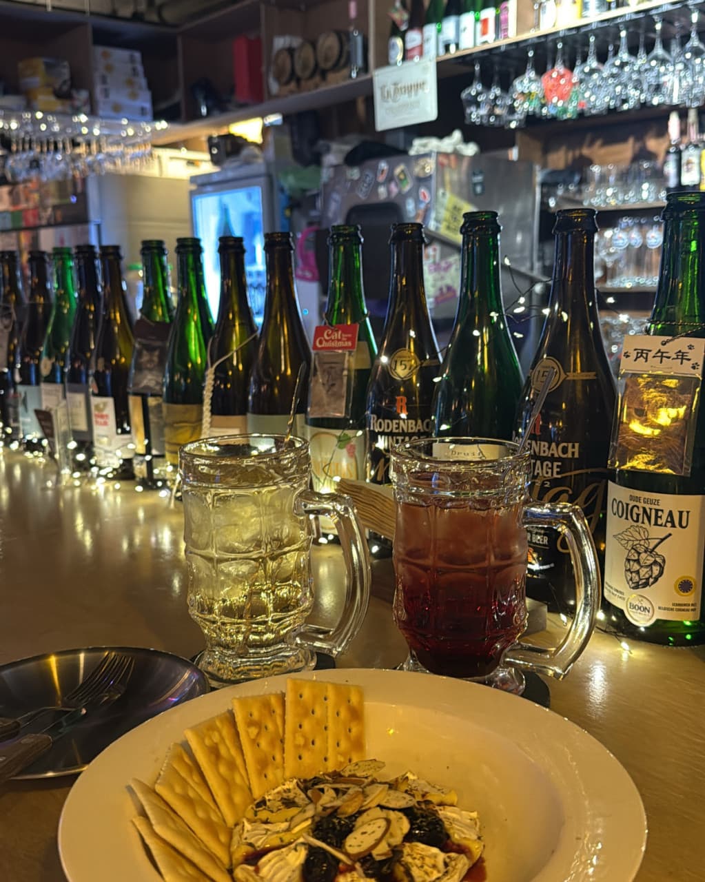 대전광역시 서구 요리주점 한잔 대전의 1인 다찌석에 차려진 하이볼과 바삭한 크래커. 노란 전구 조명이 비치는 카운터에서 즐기는 혼술 상황을 보여줌.