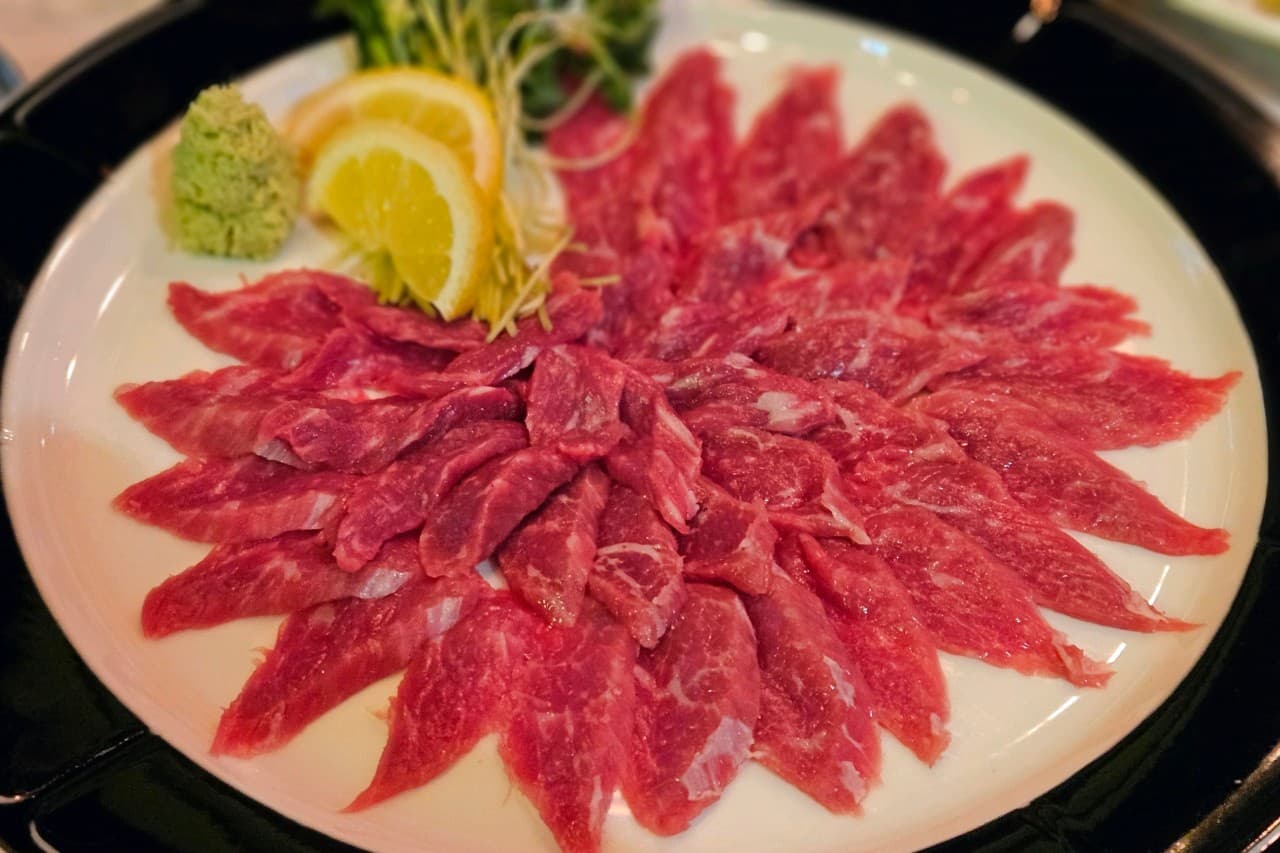 경기도 남양주시 요리주점 빅파이브 다산역점 경기 다찌석 조명 아래 차려진 1인 혼술 차림. 선홍빛 육사시미와 레몬, 와사비가 원형으로 배열된 접시의 질감을 보여줌.