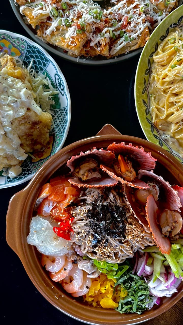 경기도 고양시 심야식당 세솔리 경기 이자카야 다찌석에 차려진 가리비와 연어 1인 해산물 소바. 치즈 가루를 얹은 전과 파스타가 포함된 혼술 상차림.