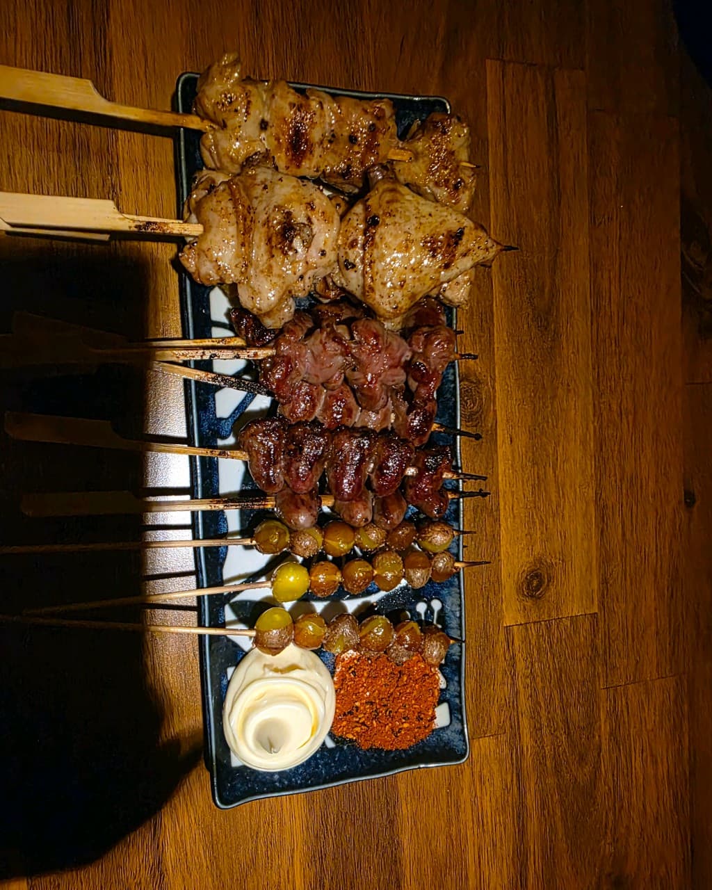 대구광역시 북구 이자카야 고요 대구의 혼술 다찌석 상황. 어두운 나무 테이블 위로 노릇하게 구워진 닭꼬치와 염통, 은행 꼬치가 마요네즈와 함께 차려진 1인 식사 모습.