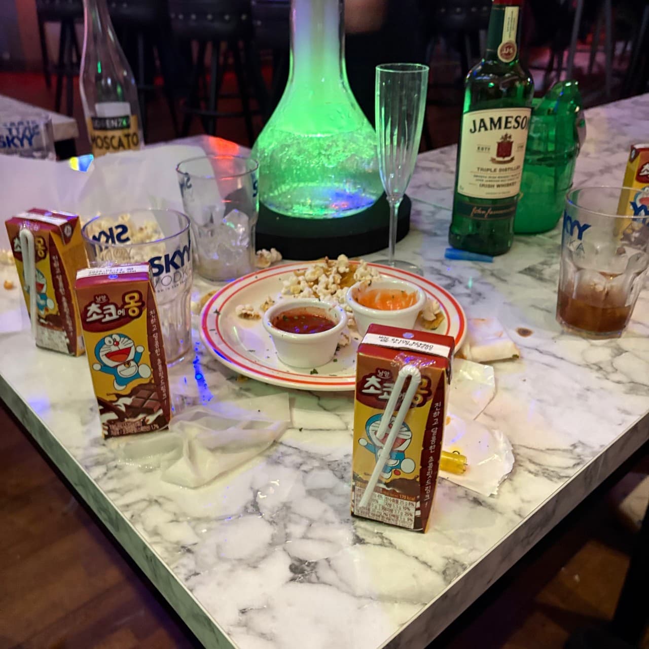 대구광역시 중구 고고펍 대구 맥주 호프. 대리석 테이블 위 제임슨 위스키와 초코우유, 팝콘 안주가 초록색 조명 기구 옆에 놓인 1인 혼술 상황.