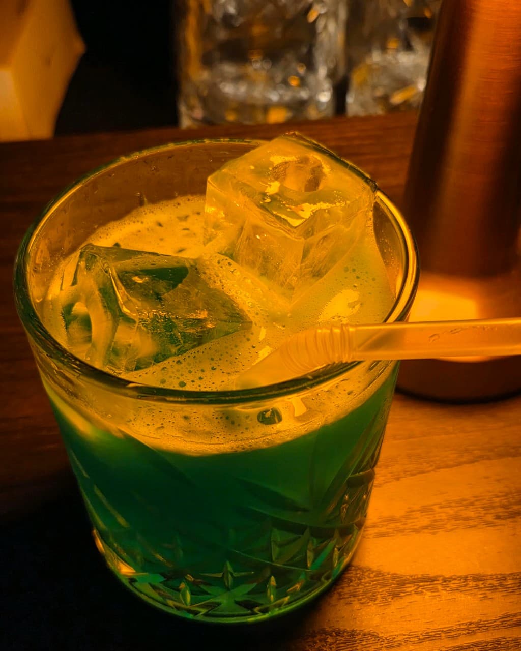 대구광역시 중구 블렌딩바 대구혼술바 교동점 바(Bar) 다찌석 조명 아래 놓인 기포 섞인 초록색 칵테일과 투명한 각얼음. 1인 좌석 혼술 상황.