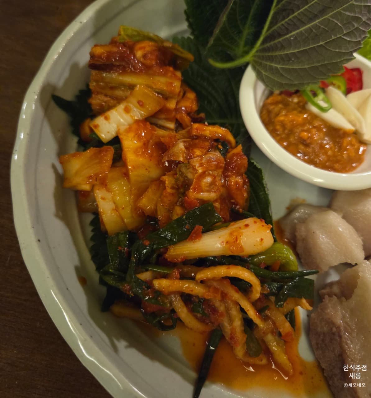 대구광역시 수성구 요리주점 한식주점 새롬 대구 다찌석 1인 보쌈과 김치. 조명 아래 쌈장과 마늘이 곁들여진 혼술 안주 차림.