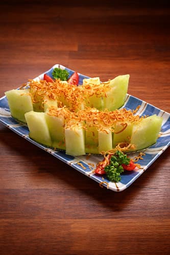 인천광역시 연수구 로바타키요 송도본점 인천 이자카야 다찌석 조명 아래 놓인 브라운 치즈 멜론. 1인 혼술 안주의 질감이 드러나는 나무 테이블 위 차림새.