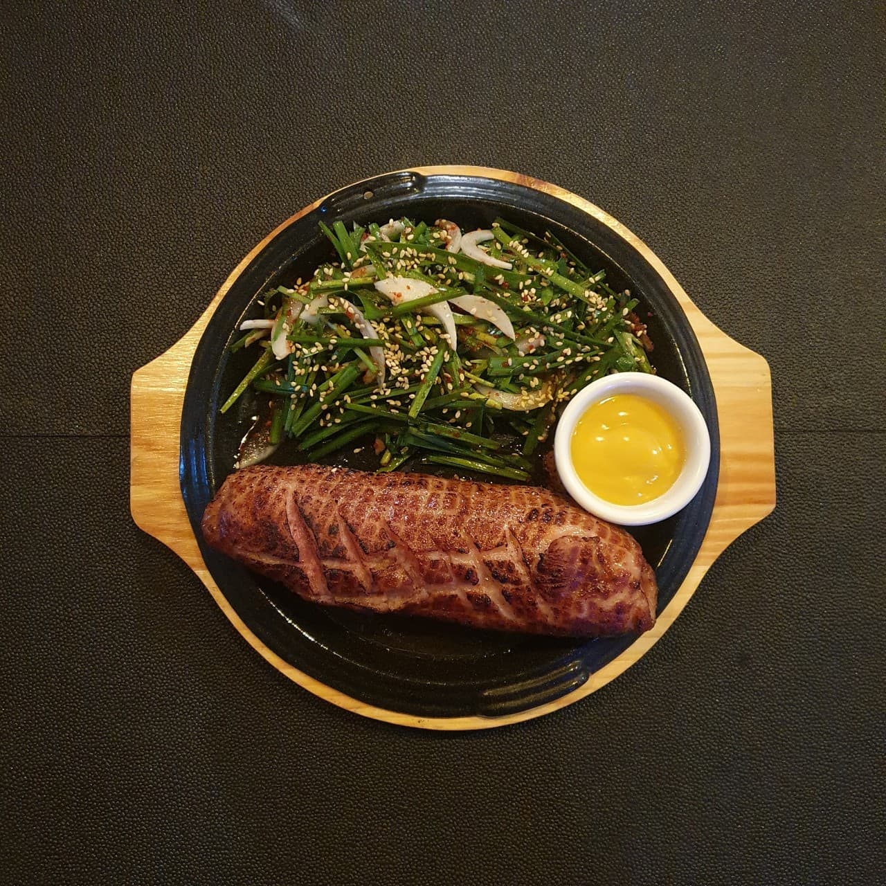 인천광역시 영종구 요리주점 촤랑 인천 - 다찌석 조명 아래 1인 혼술 메뉴인 칼집 낸 소시지 구이와 부추무침, 머스터드 소스가 차려진 모습
