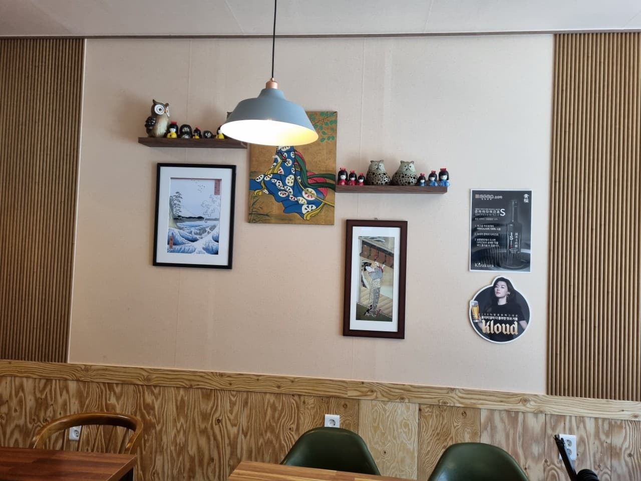 울산광역시 남구 이자카야 고꼬 펜던트 조명 아래 목재 인테리어와 일본풍 소품. 혼술 가능한 테이블 좌석과 벽면에 걸린 액자들이 일본 현지 선술집 분위기를 연출함.