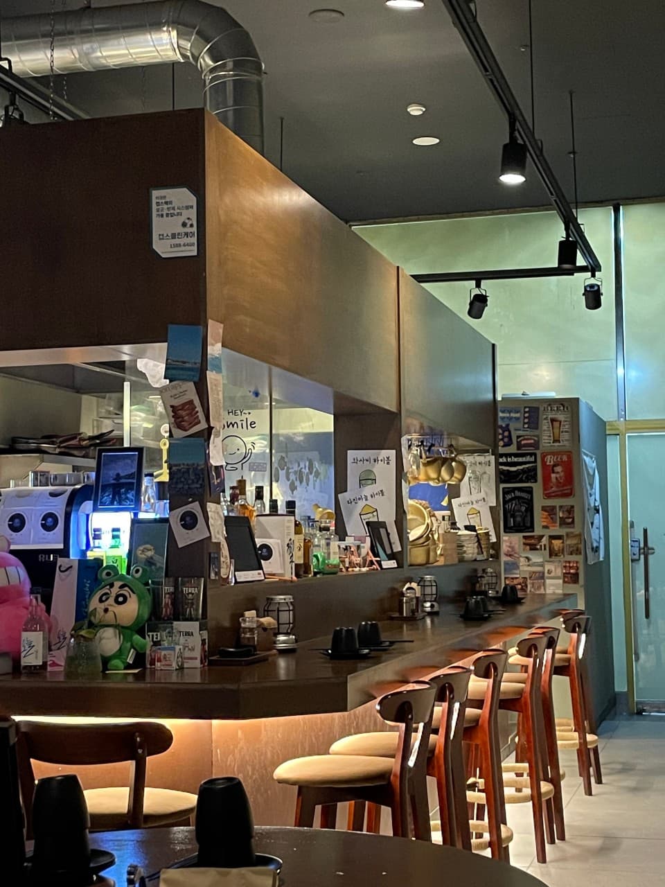 강원특별자치도 원주시 오뎅바 육지놈들 - 노란 간접 조명 아래 긴 원목 다찌석과 1인 의자가 나란히 배치된 카운터 중심의 혼술 공간