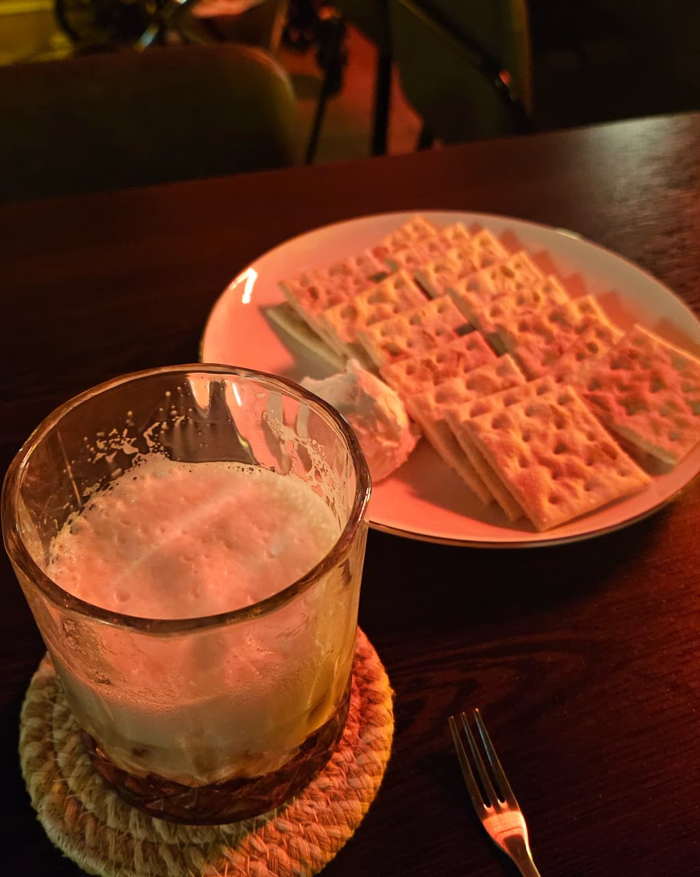 강원특별자치도 원주시 라벨라다 바(Bar)의 붉은 조명 아래 1인석 테이블. 풍성한 거품이 올라간 술과 크래커가 차려진 혼술 상황.