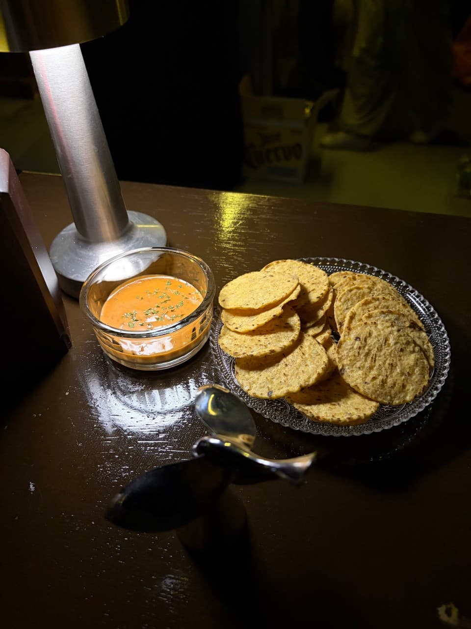 경상남도 창원시 노웨이브 창원혼술바 상남점 다찌석 조명 아래 놓인 바삭한 나초와 주황색 소스. 1인 전용 좌석에서 혼술을 즐기는 바(Bar)의 구체적인 상황.