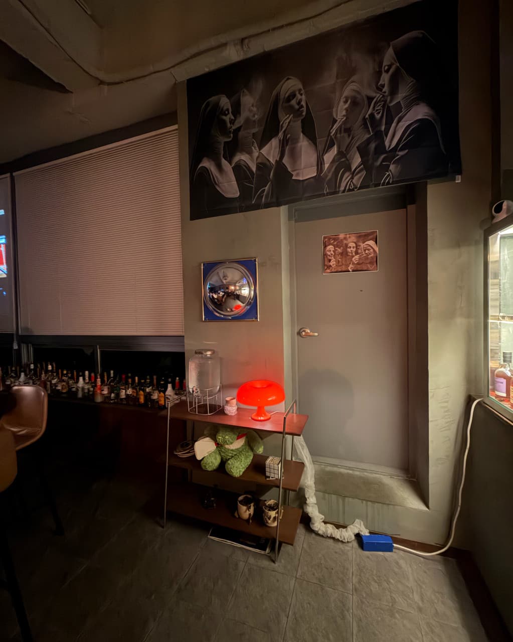 충청북도 청주시 야화 혼술바 청주율량점 바(Bar) 실내. 붉은 오렌지색 조명과 벽면의 대형 흑백 포스터, 창가에 나열된 술병들이 1인 혼술 전용 공간의 특징을 보여줌.