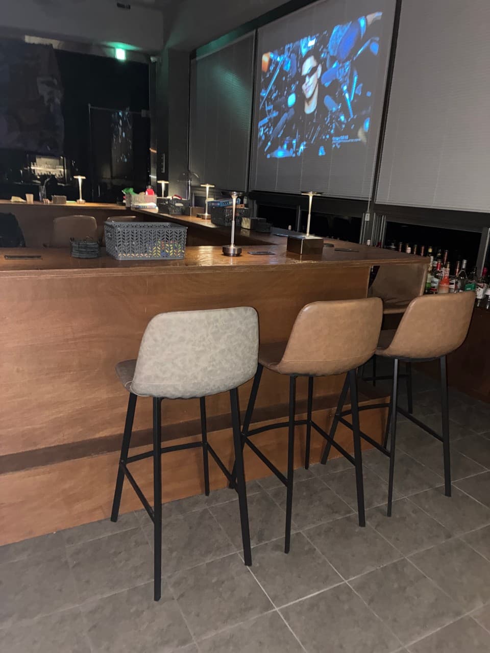 충청북도 청주시 야화 혼술바 청주율량점 바(Bar) 내부의 나무 다찌석과 높은 의자. 테이블 스탠드 조명과 대형 스크린 영상이 투사되는 혼술 전용 카운터석 배치.