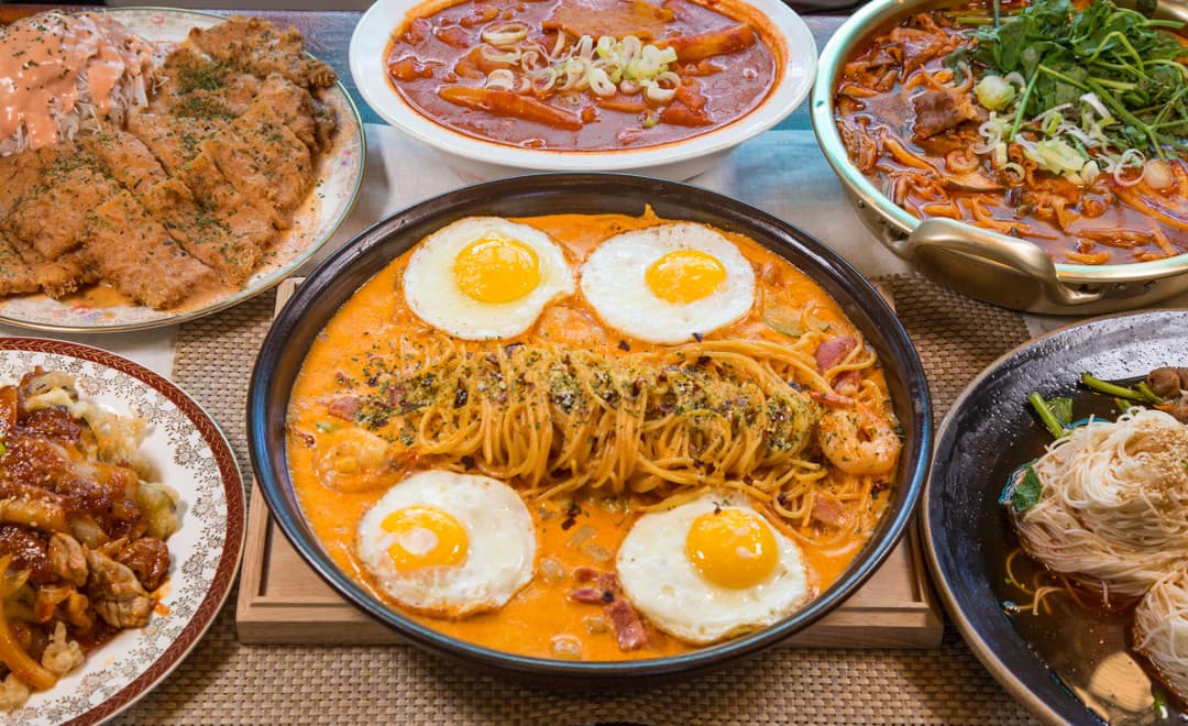 서울특별시 동작구 돈키호테 사당이수본점 맥주 호프. 조명 아래 반숙 계란 로제 파스타와 돈가스가 차려진 다찌석 1인 혼술 차림. 소스의 질감과 여러 종류의 안주 구성.