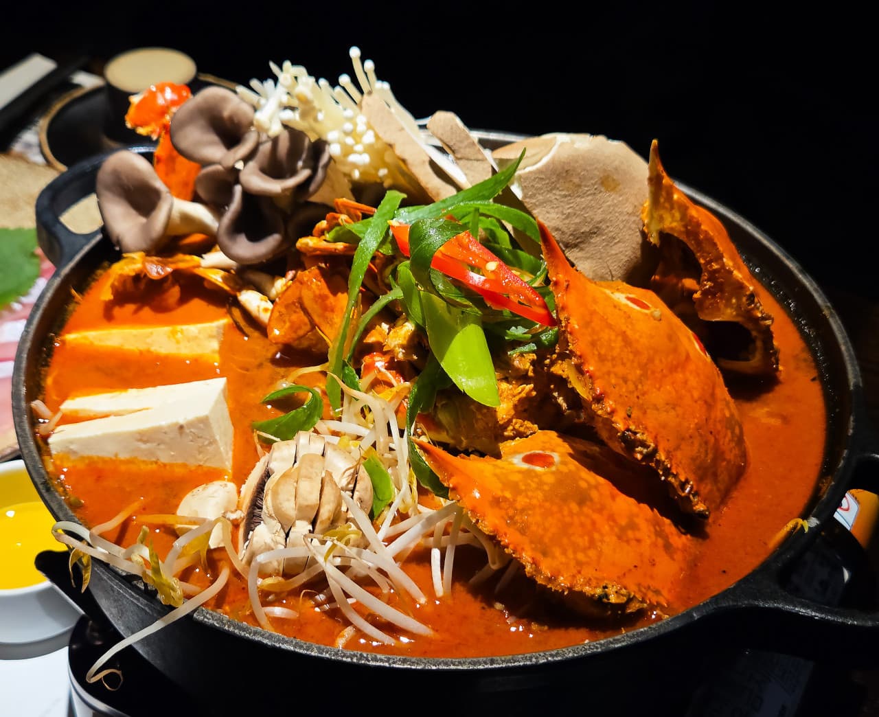 충청북도 청주시 요리주점 야키토리잔잔 충주복대점 다찌석 혼술 전골. 주황색 꽃게와 버섯, 두부가 담긴 빨간 국물이 조명 아래 강조된 1인 좌석 식사 상황.