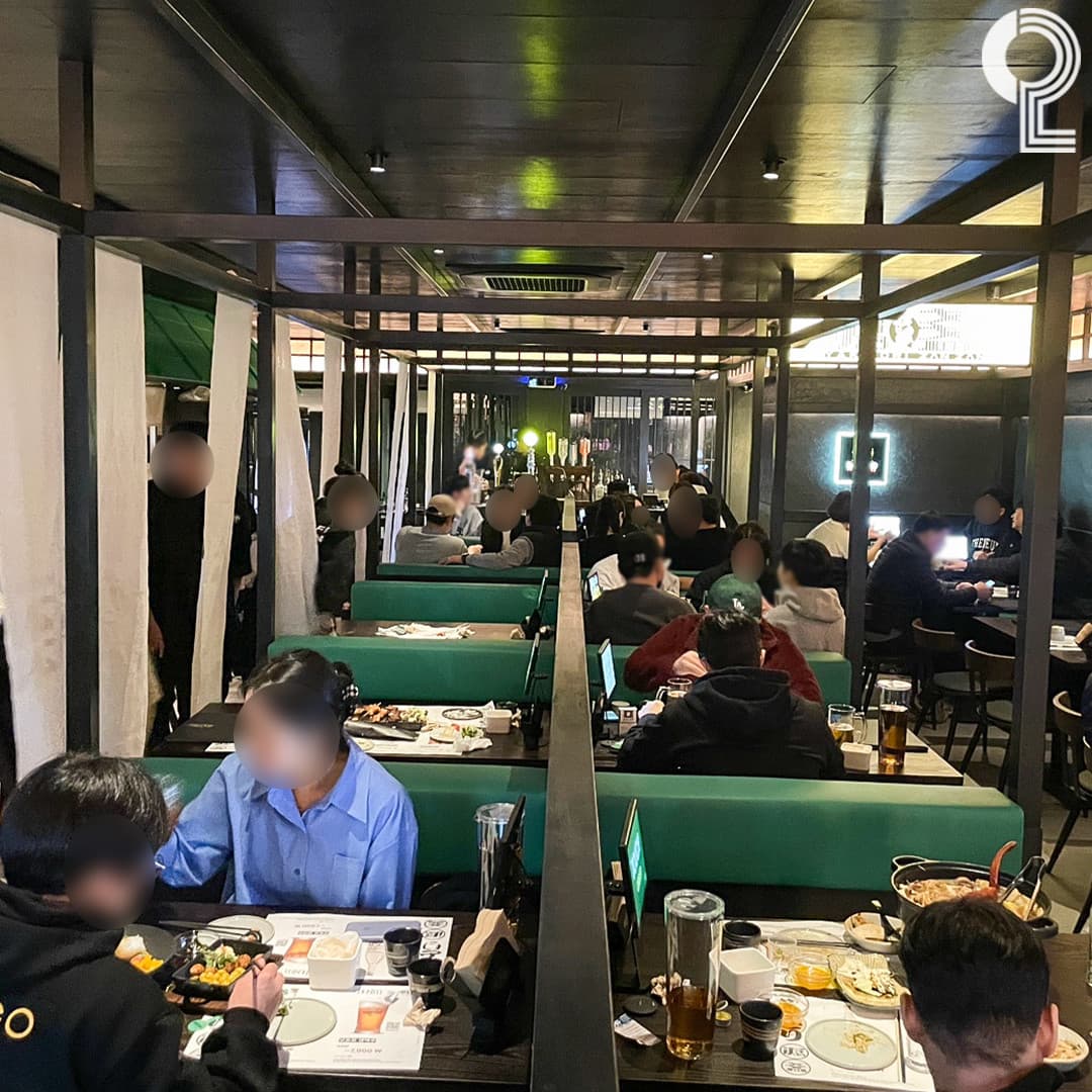 충청북도 청주시 요리주점 야키토리잔잔 충주복대점의 낮은 조도 아래 배치된 꼬치 요리와 주류. 1인 혼술이 가능한 다찌석과 초록색 칸막이 좌석이 위치한 공간.